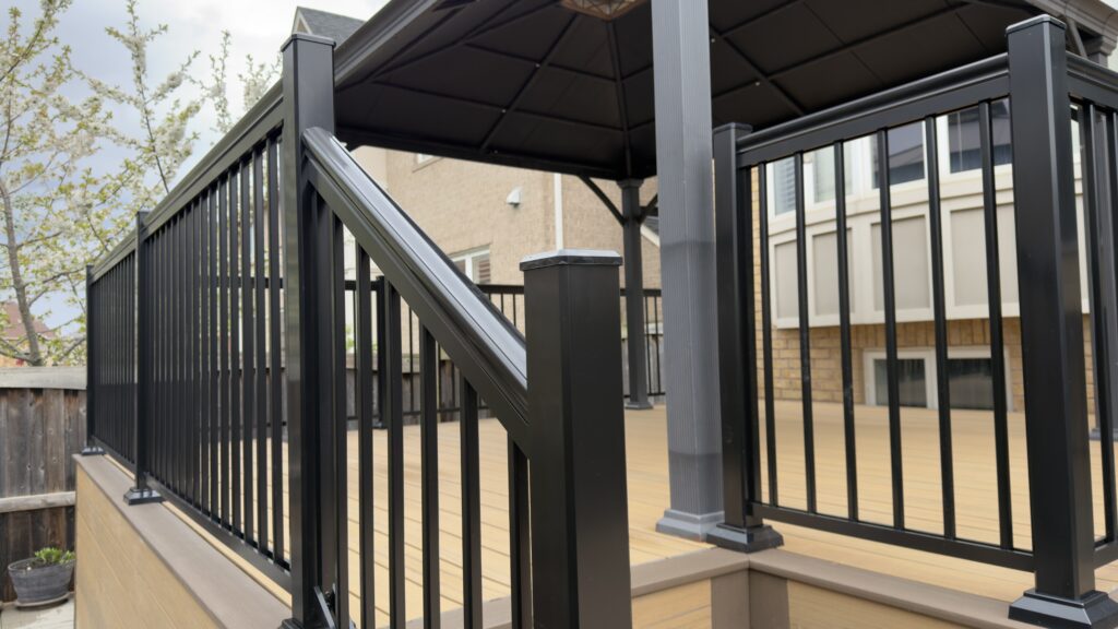 Contemporary aluminum deck railing system with stairs and composite decking in residential backyard